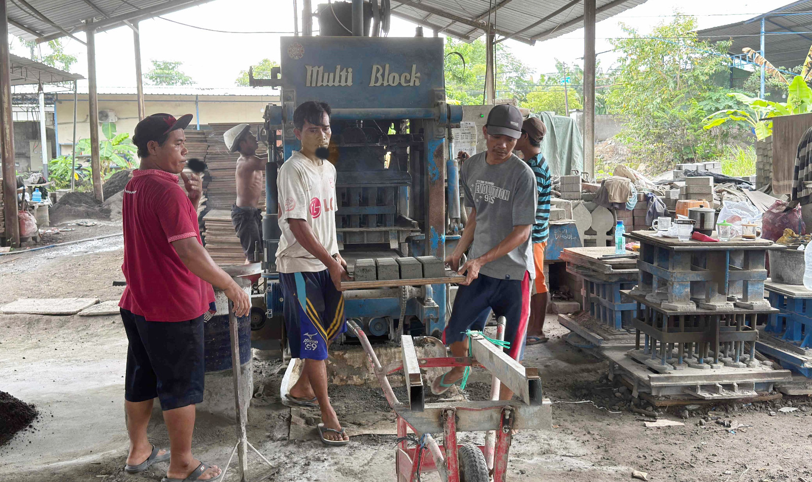 OPERASIONAL BUMD: Para pekerja PT GNE saling bekerja sama, memproduksi paving block, beberapa waktu lalu.