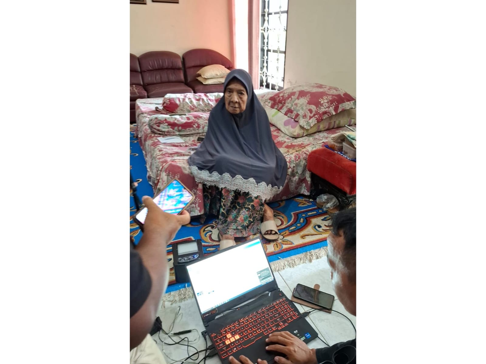 Petugas dari Dinas Dukcapil Kota Mataram saat melakukan perekaman pada Siti Chadijah di tempat tidurnya.
