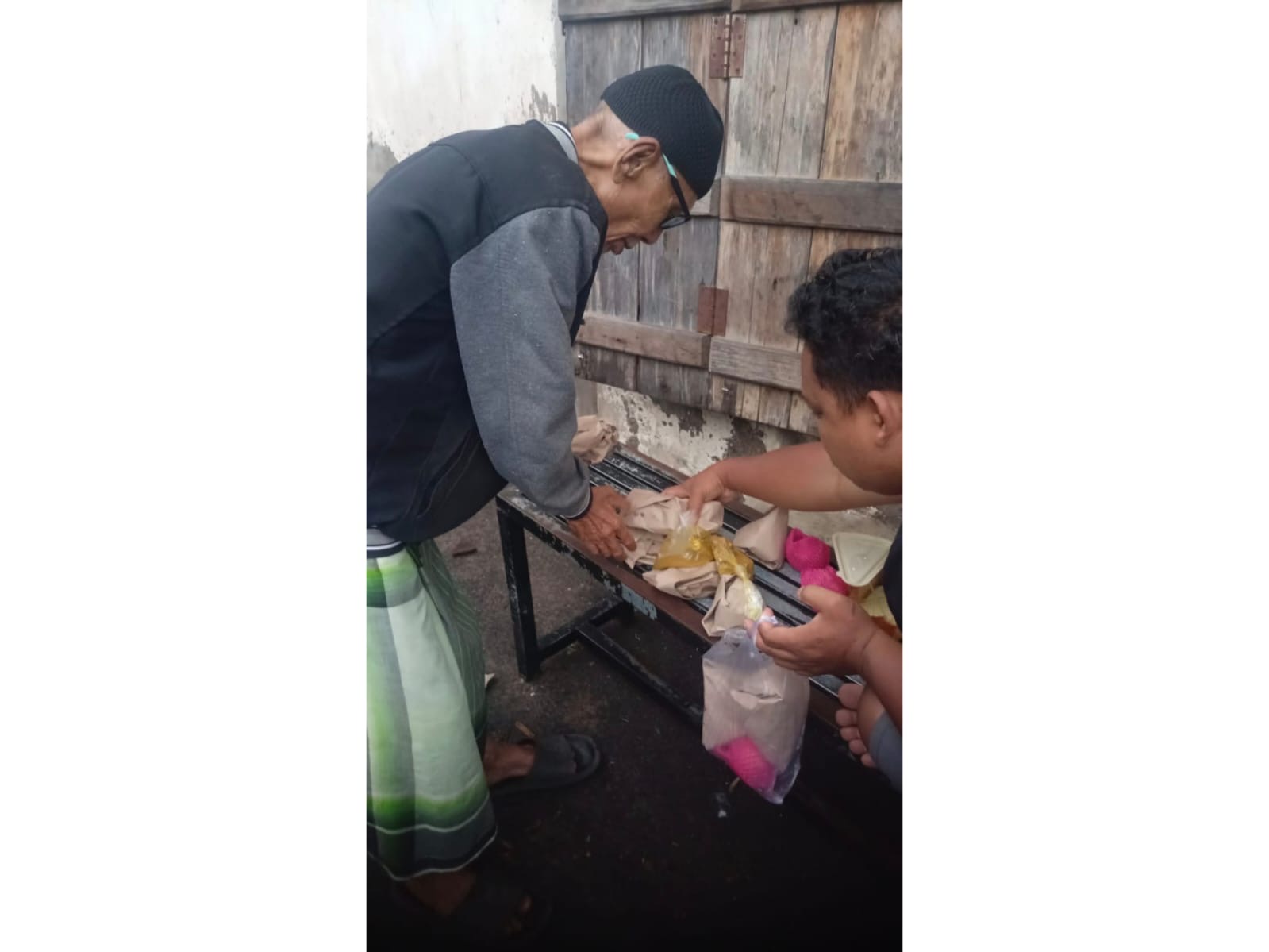 Warga Bintaro yang tengah menerima bantuan makanan dari Tagana saat cuaca buruk.