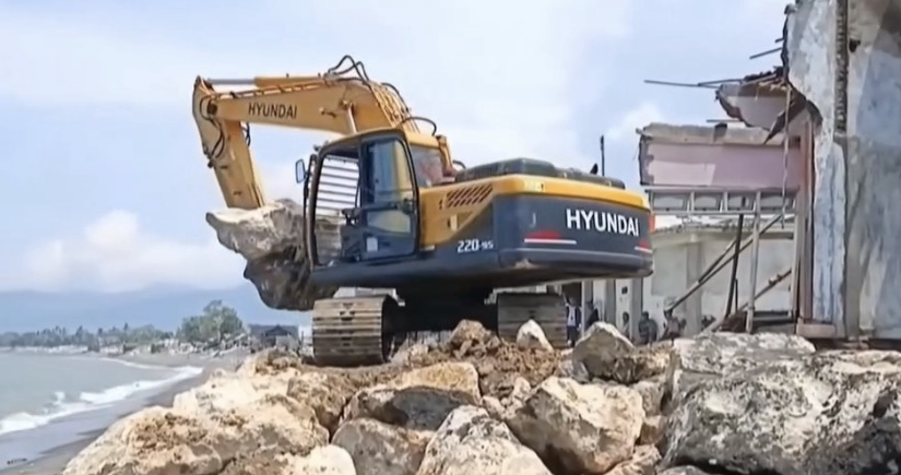 Alat berat tengah menyusun batu bolder di kawasan Kampung Bugis.