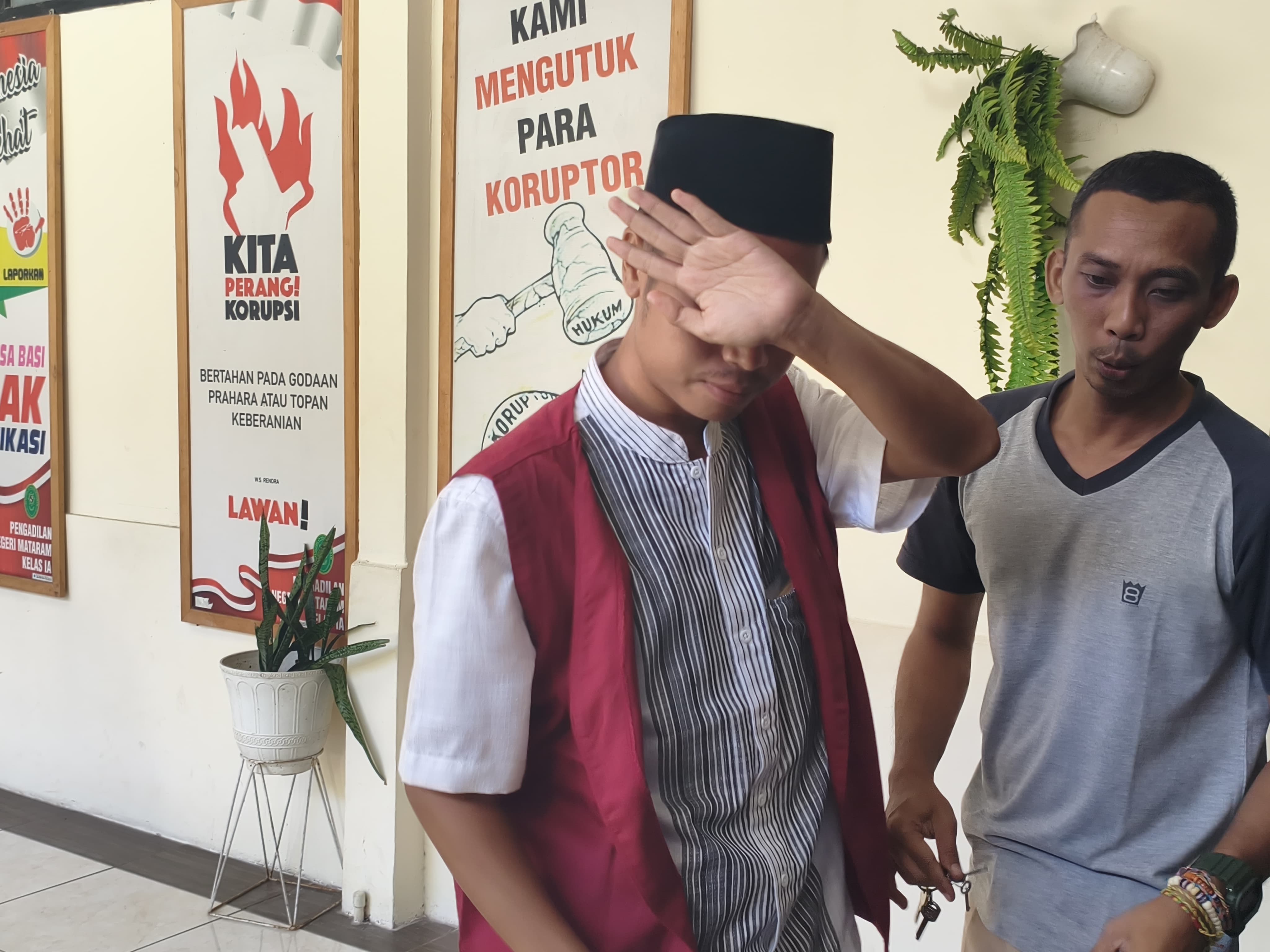 HINDARI SOROTAN KAMERA: Terdakwa kasus pelecehan seksual sesama jenis Lalu Rudy Rustandi dikawal jaksa menuju ruang tahanan usai pembacaan putusan di Pengadilan Negeri Mataram, Rabu (4/2).