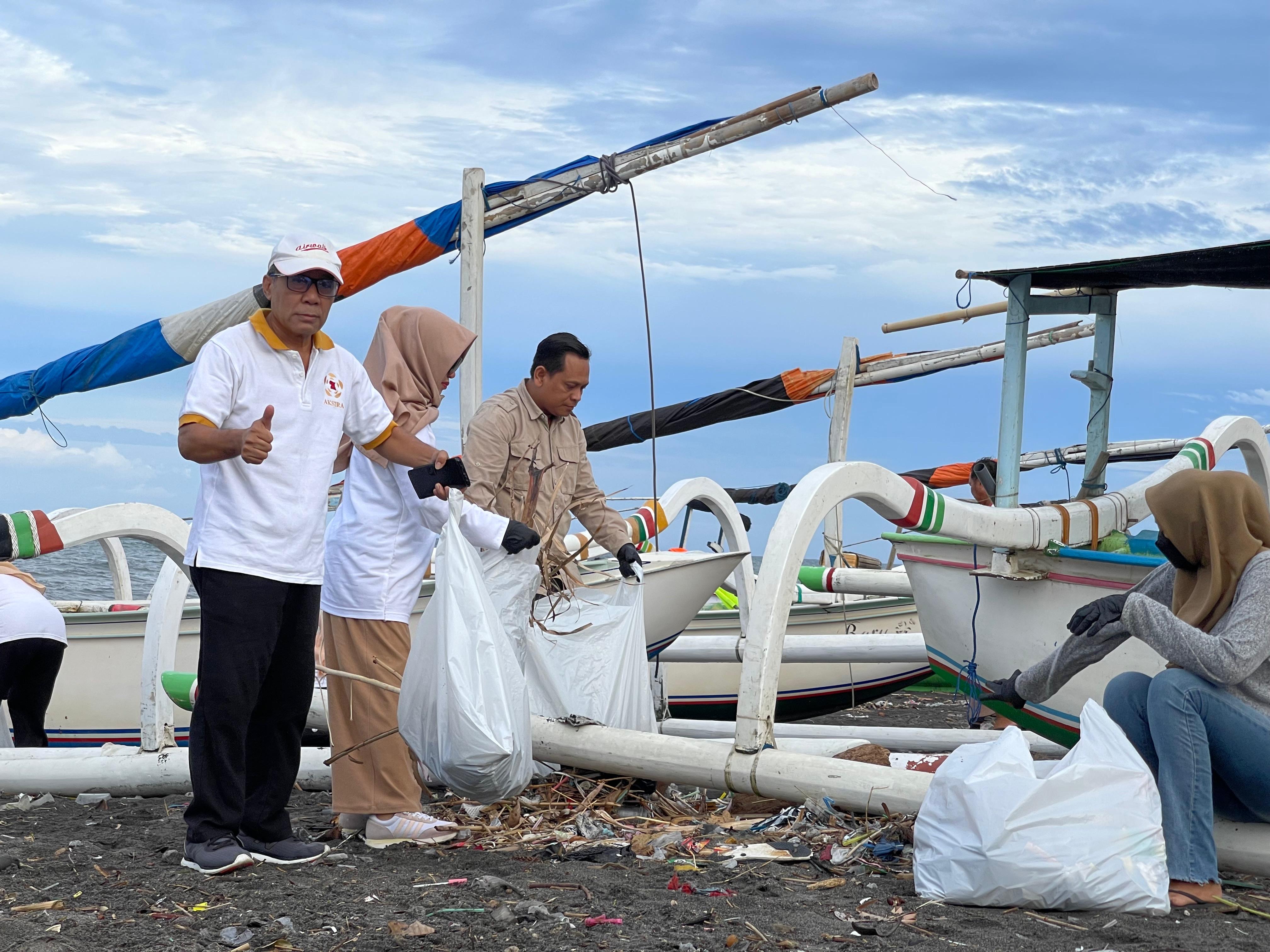 Ketua Panitia HUT ke-18 Partai Gerindra Kota Mataram Herman ( baju coklat) bersama anggota DPRD dari partai Gerindra bersih pantai Tanjung Karang.