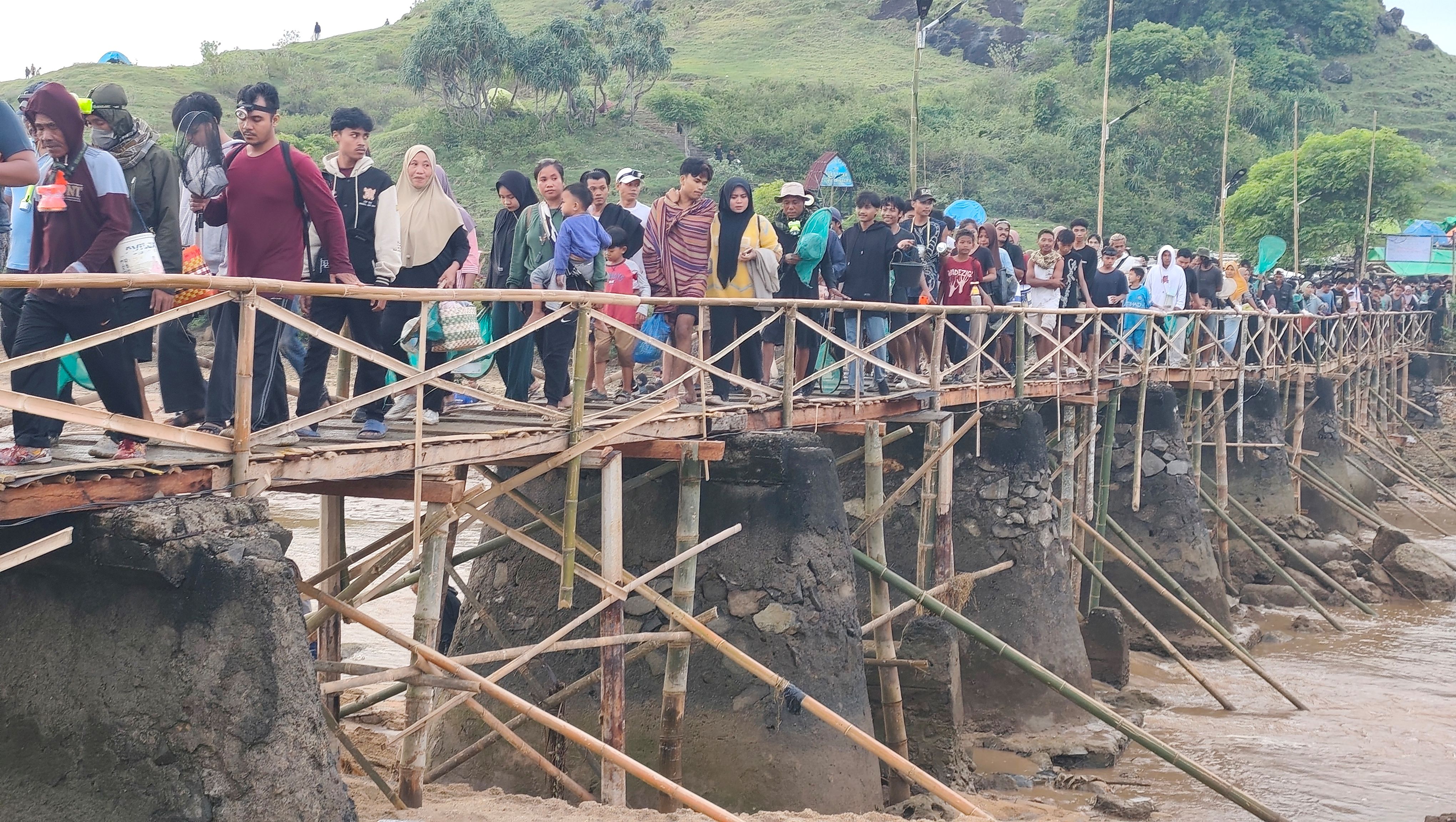 Ribuan masyarakat berbondong-bondong melintasi jembatan usai turun dari Bukit Seger, Pantai Seger, Desa Kuta, Pujut, Lombok Tengah, Minggu (8/2) lalu.