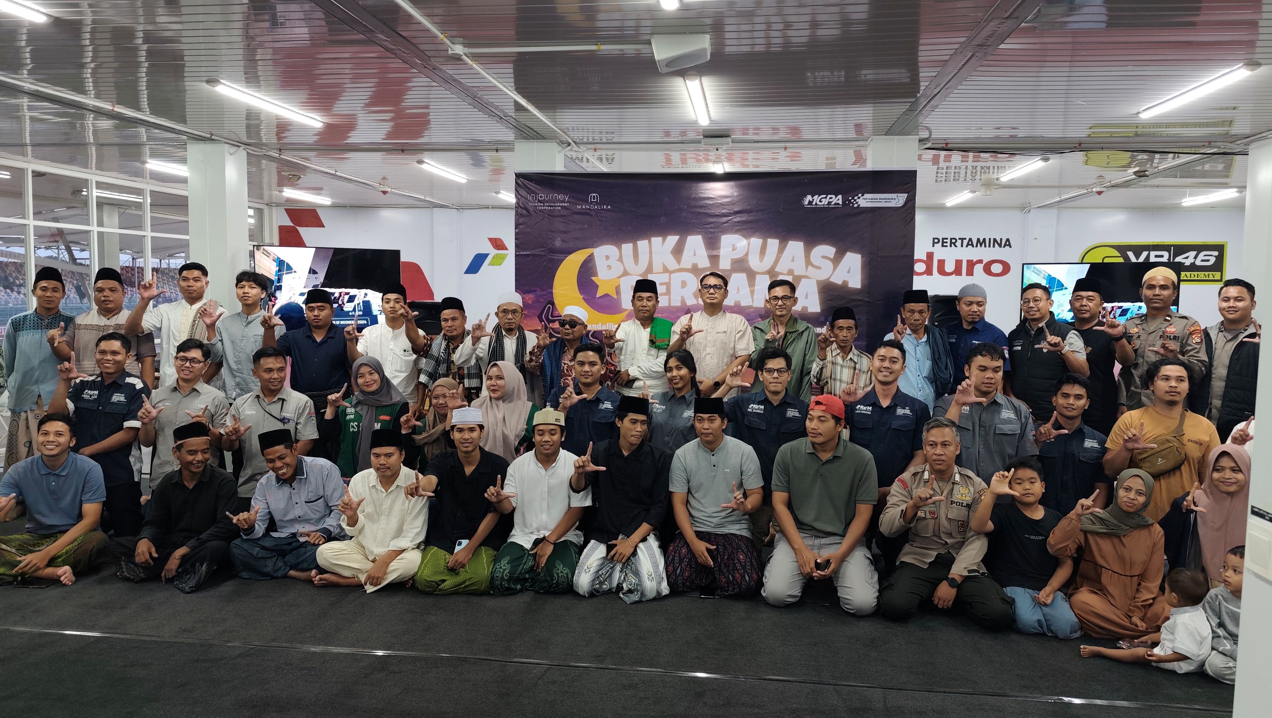 Seratus orang warga bersama MGPA berfoto bersama menjelang waktu berbuka puasa bersama di Dining Hall Sirkuit Internasional Mandalika, Jumat (27/2).