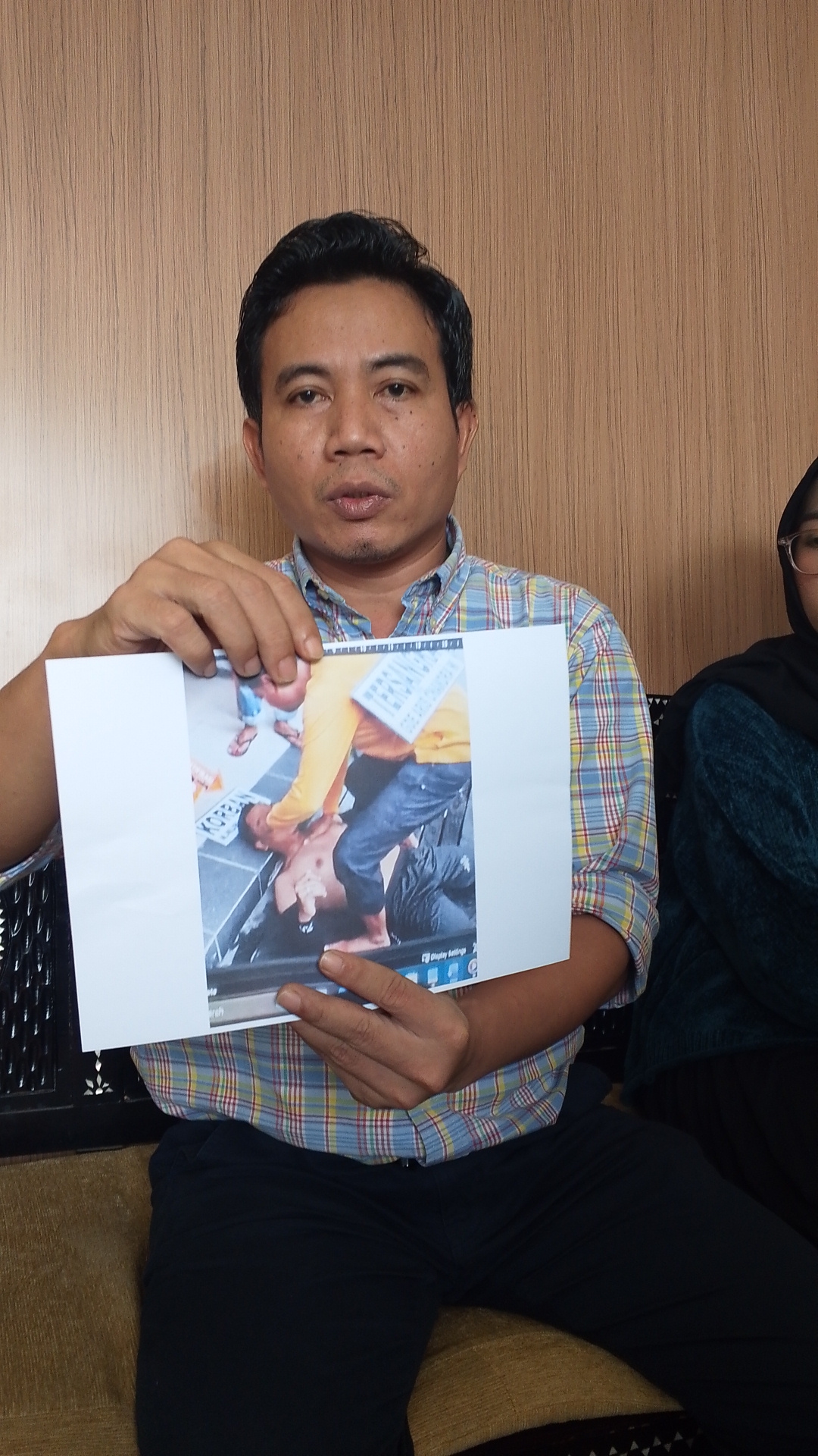 TUNJUKKAN BUKTI: Penasihat Hukum Kompol Yogi, Suhartono menunjukkan foto hasil rekonstruksi polisi yang dikaitkan dengan fakta persidangan, Minggu (1/3).