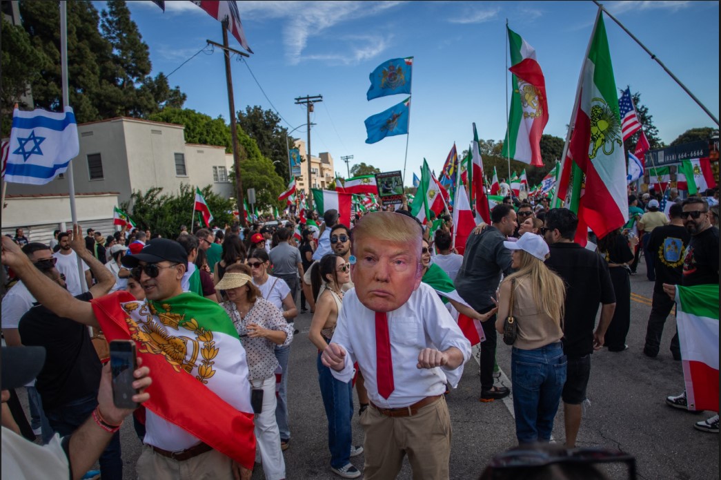 DIDEMO: Seorang pria mengenakan topeng Presiden AS Donald Trump saat anggota komunitas Iran berdemo di depan Gedung Federal, Los Angeles, California, Minggu (1/3). 