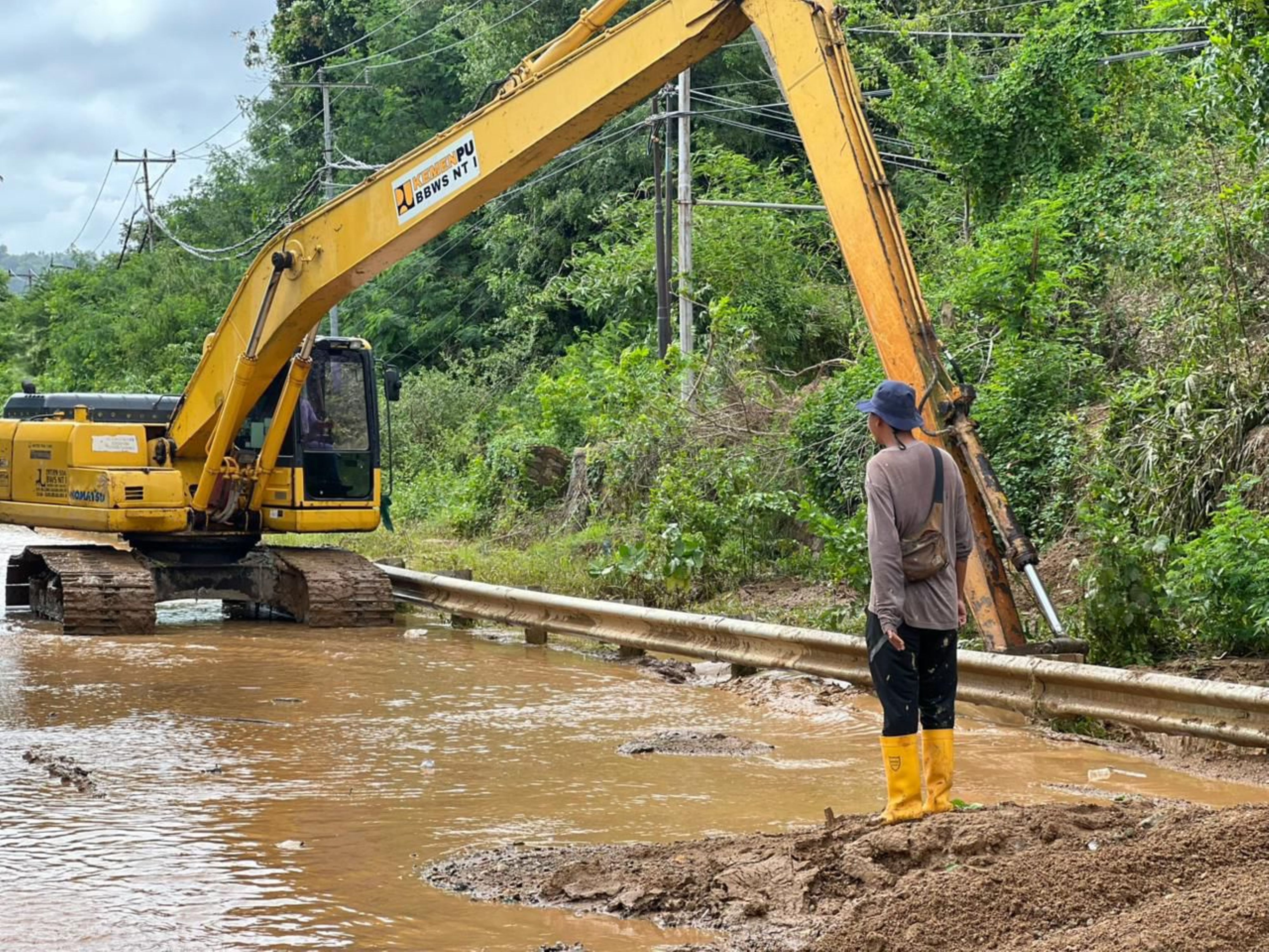 Alat berat ekskavator diturunkan untuk membersihkan limpasan air dan lumpur yang menutupi jalan dan drainase jalan raya wisata Kuta atau depan Sirkuit Internasional Mandalika, belum lama ini.
