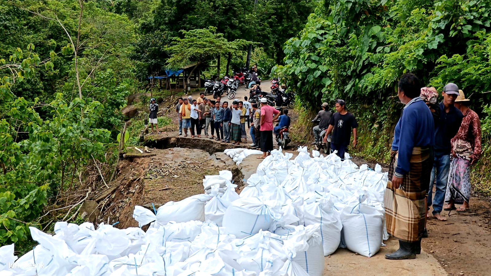 PENANGANAN DARURAT: Tim BPBD saat berupayan melakukan penanganan darurat dengan memasang Geobag di jalan Buwun Mas &ndash; Taman Sari yang amblas akibat bencana.