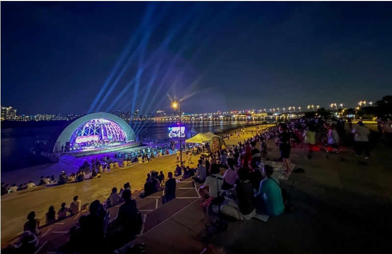 Perairan Sungai Hangang dan di sembilan Taman Hangang. Menunjukkan warga Kota Seoul yang sedang menikmati pertunjukan Hangang Summer Music Picnic yang digelar di Taman Hangang Yeouido.