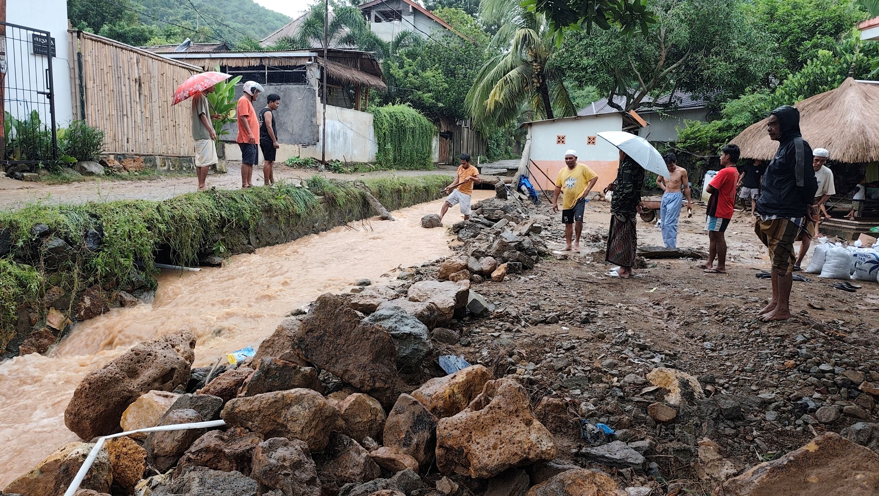 Warga bergotong royong mengangkut bebatuan yang terbawa arus hujan dan banjir dari atas perbukitan di Dusun Mengolang, Desa Kuta, Pujut, Lombok Tengah, beberapa waktu lalu.