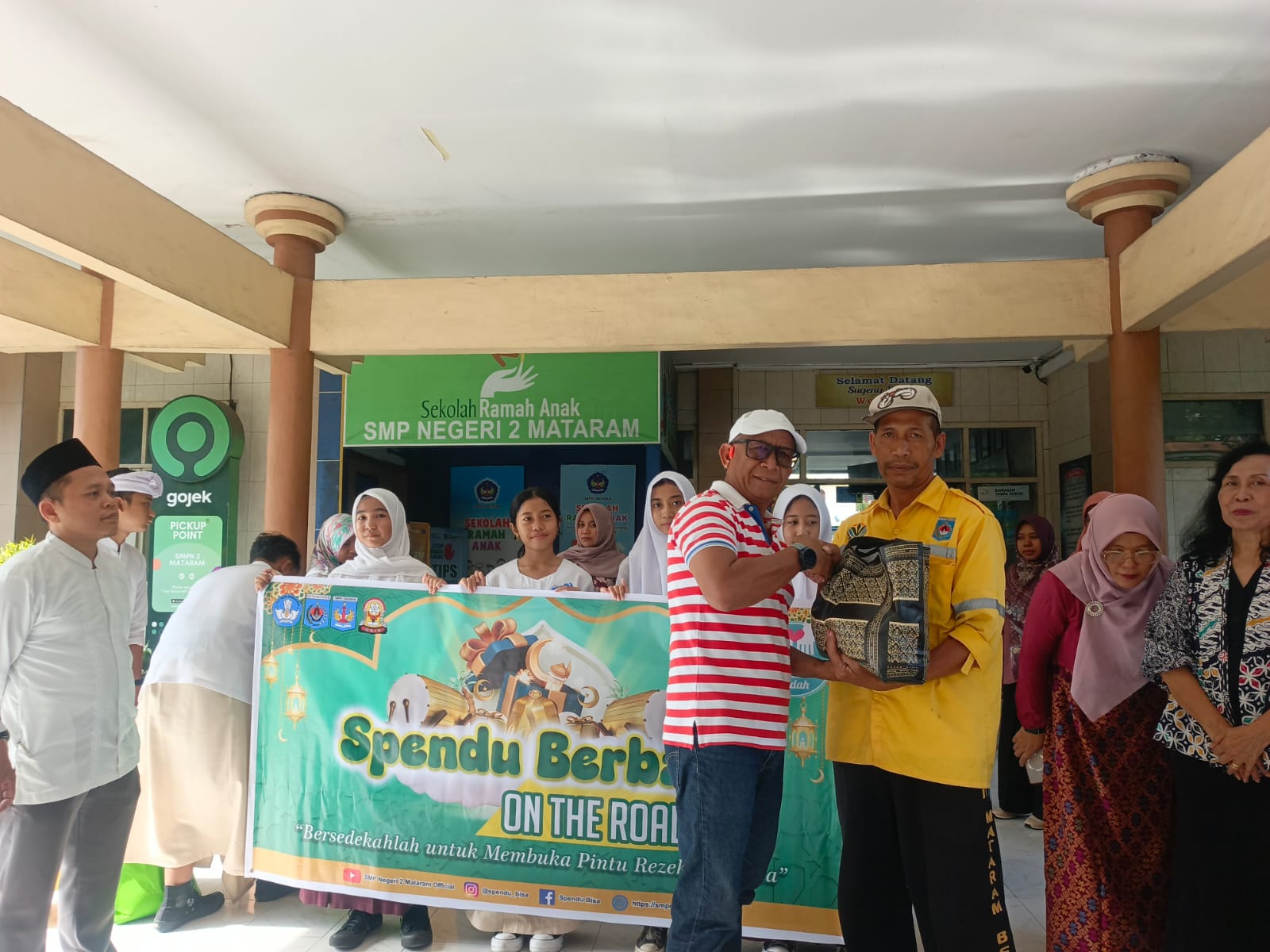 Ketua Komite SMPN 2 Mataram H Andy Hadianto menyerahkan paket sembako kepada warga.