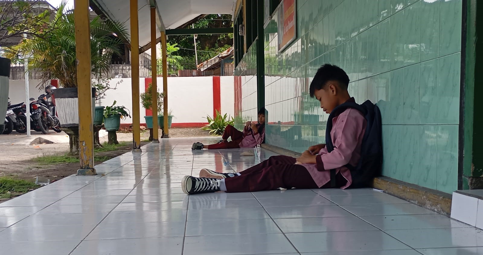 Dua murid SD di Kota Mataram menunggu jemputan saat pulang sekolah, belum lama ini. Anak tidak sekolah di NTB masih tinggi, dipicu pekerja anak dan perkawinan dini.
