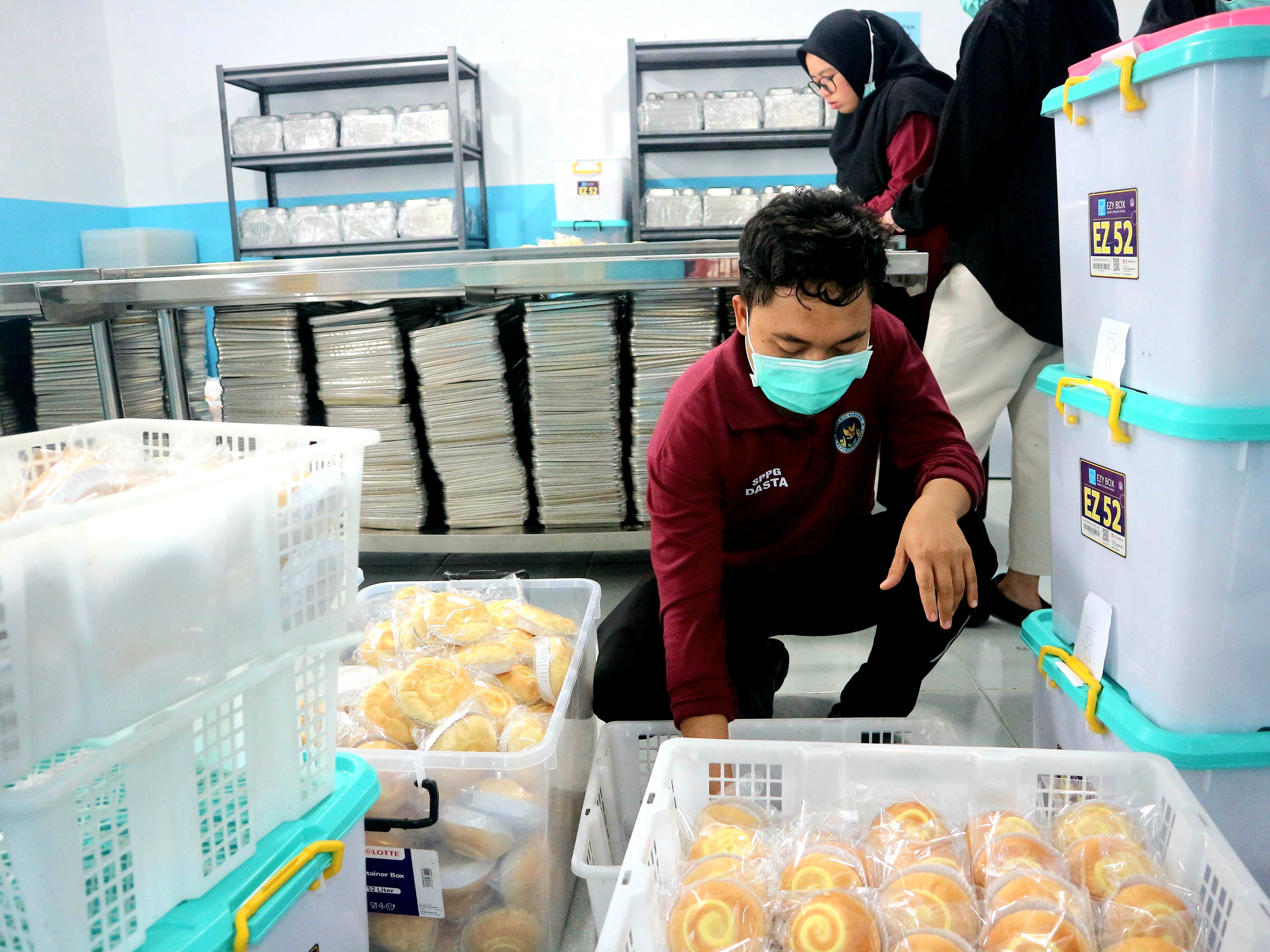 Petugas SPPG Dasan Tapen menyiapkan menu bagi penerima manfaat. 