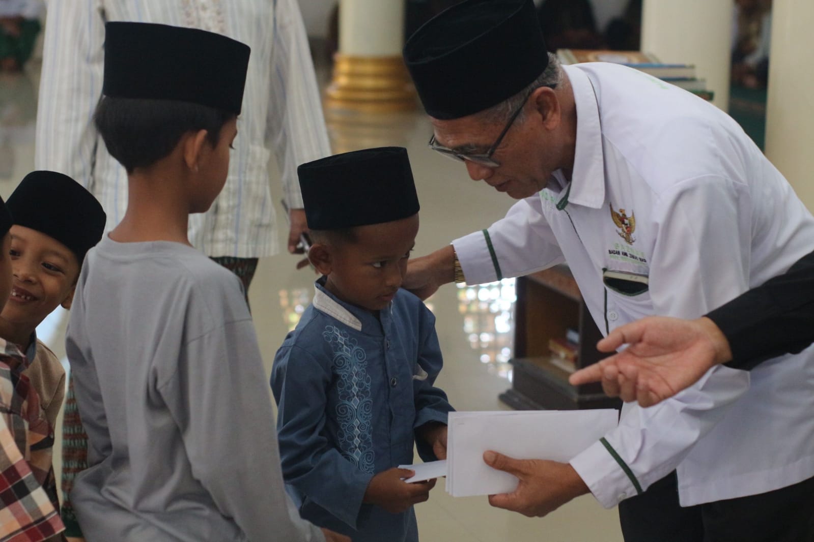 Wakil Ketua IV Baznas NTB Ahmad Rusli saat menyerahkan santunan kepda puluhan anak yatim piatu di Desa Dasan  Borok, Kecamatan Suralaga.  