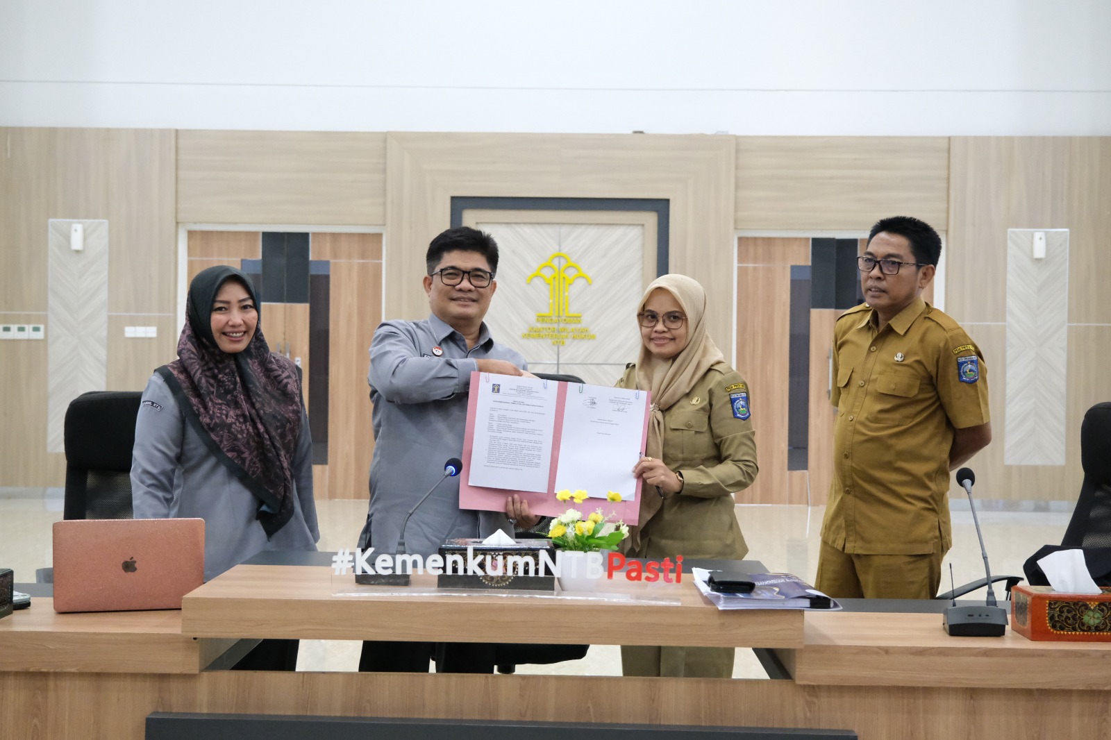 Kadiv Perancang Peraturan Perundang-undangan dan Pembinaan Hukum Edward James Sinaga menyerarkan berita acara pembahasan bersama Tim Biro Hukum dan Biro Pemerintahan dan Otonomi Daerah Setda NTB.
