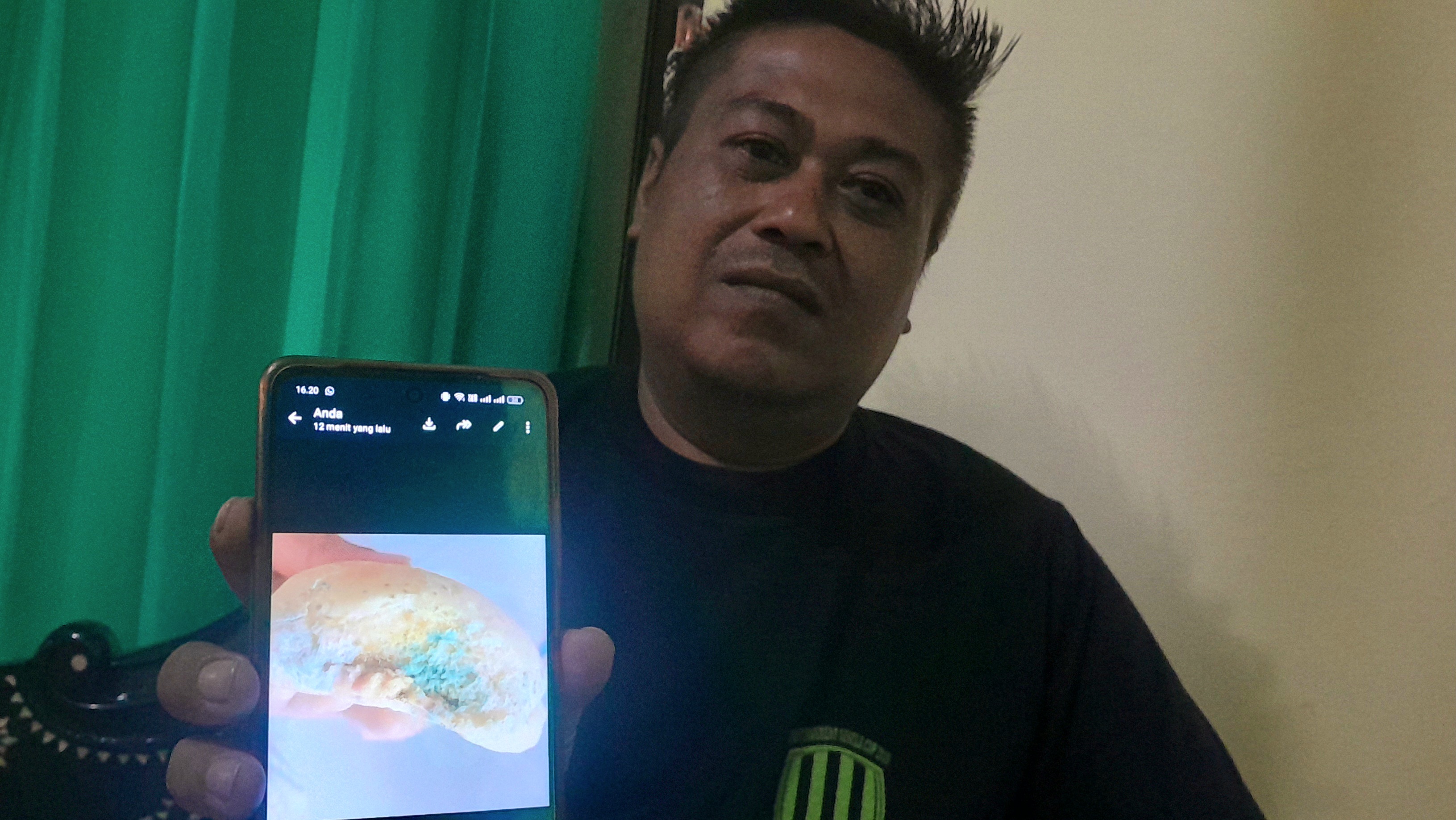 Kades Sesela M Taufik menunjukkan foto roti berjamur yang diterima anak-anak sekolah di wilayahnya.  