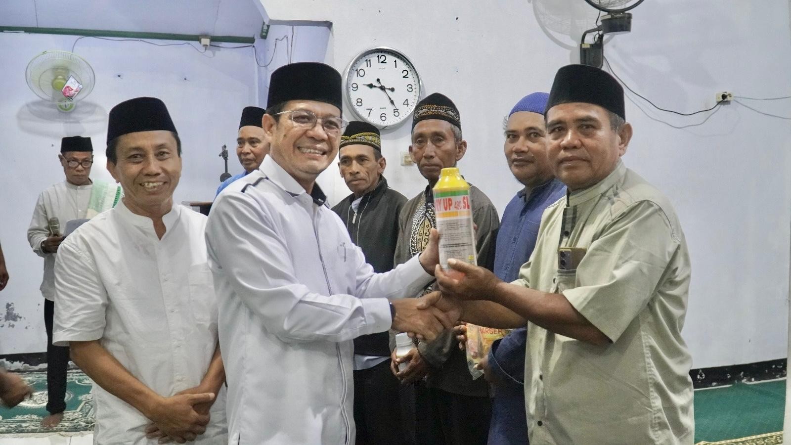Bupati Dompu  Bambang Firdaus menyerahkan bantuan kepada warga di Masjid Al Jami, Desa Mbuju, Kecamatan Kilo, Senin (9/3).