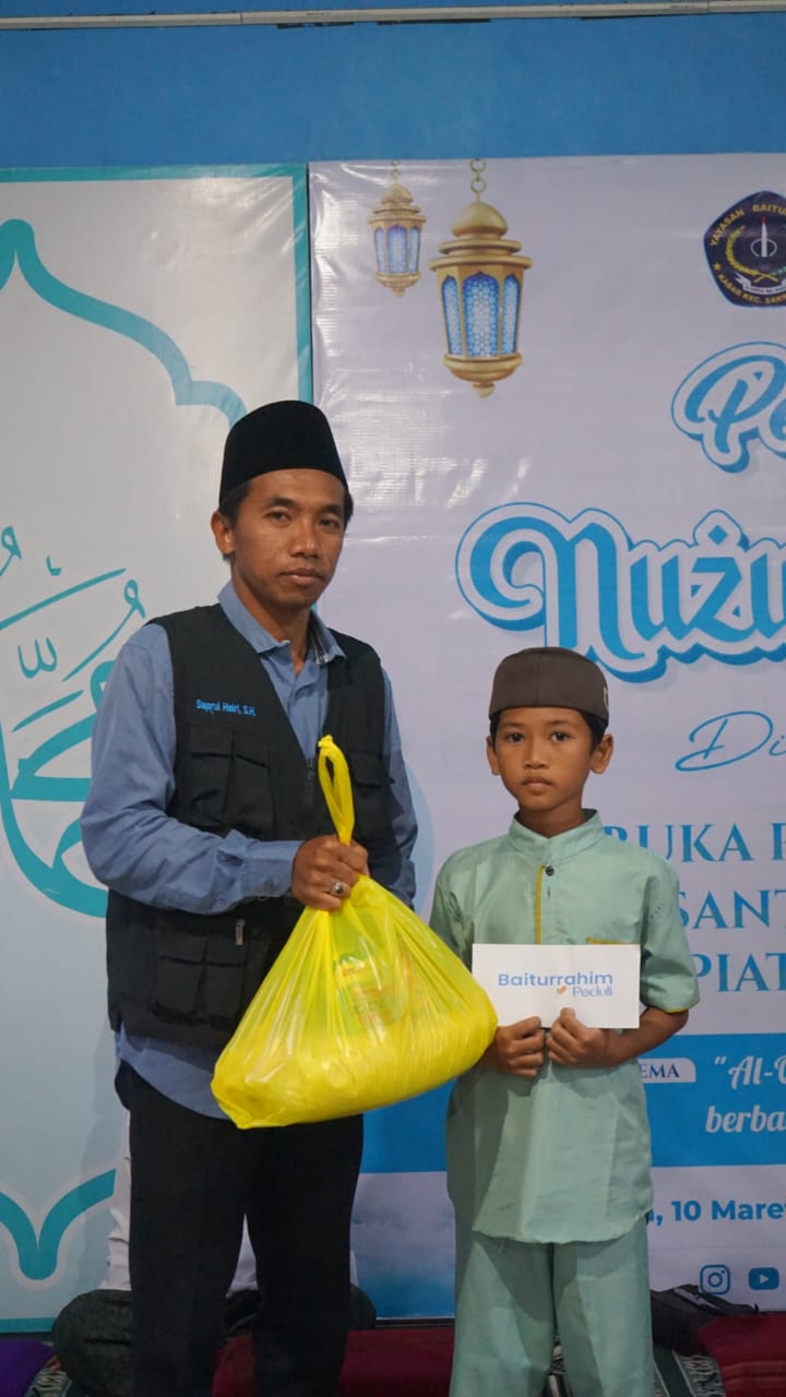 Ketua Baiturrahim Peduli Saprul Khairi saat menyerahkan santunan kepada anak yatim.
