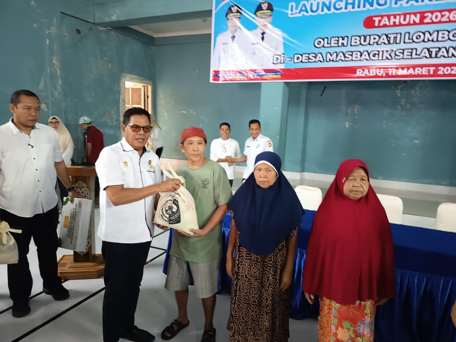 Bupati Lombok Timur Haerul Warisin menyerahkan bantuan paket sembako kepada masyarakat miskin di Desa Masbagik Selatan.