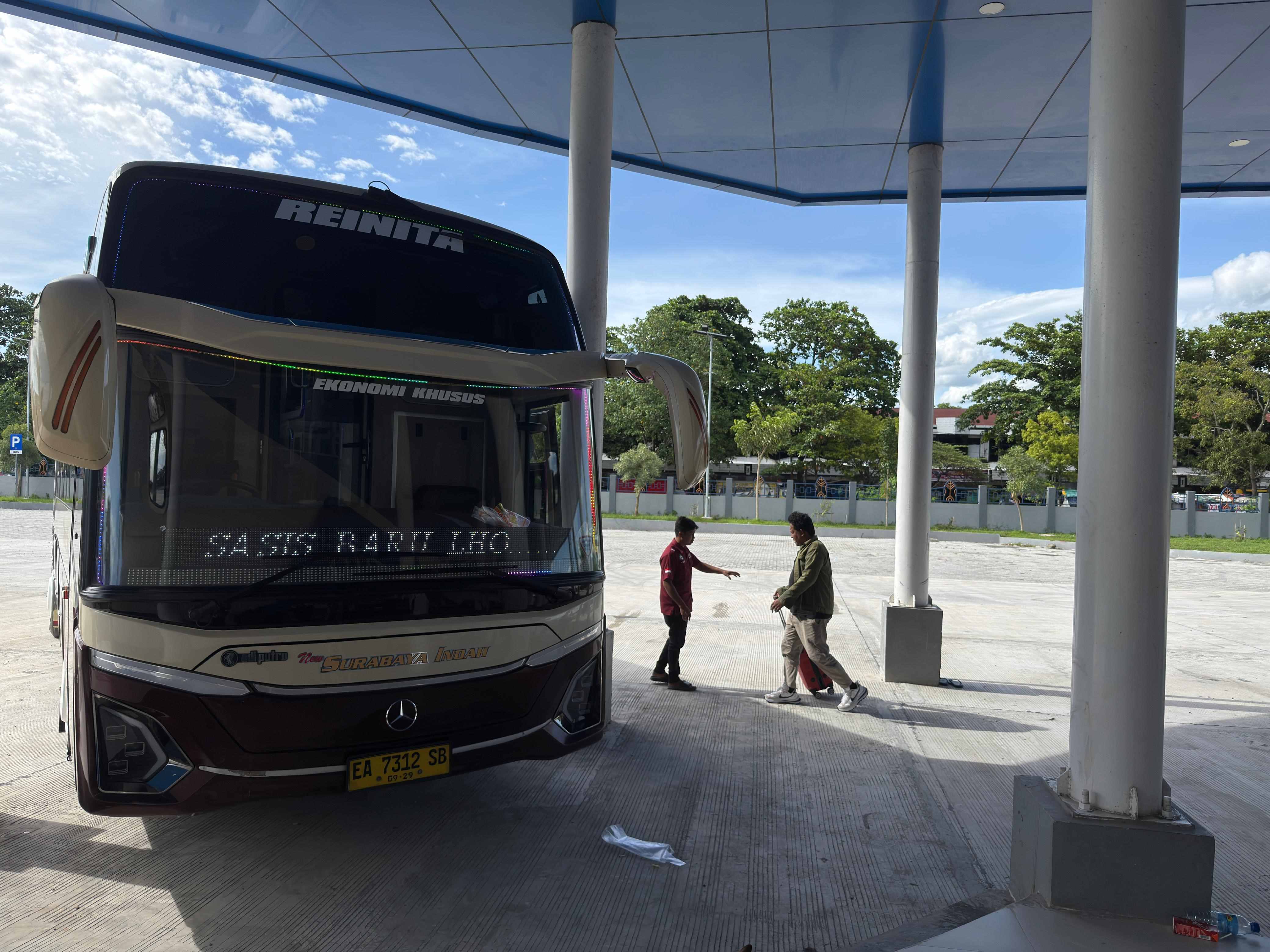 BERJUMPA KELUARGA: Seorang penumpang menggeret kopernya, menuju salah satu bus tujuan Bima yang berangkat, dari Terminal Tipe A Mandalika, Kamis (12/3). 