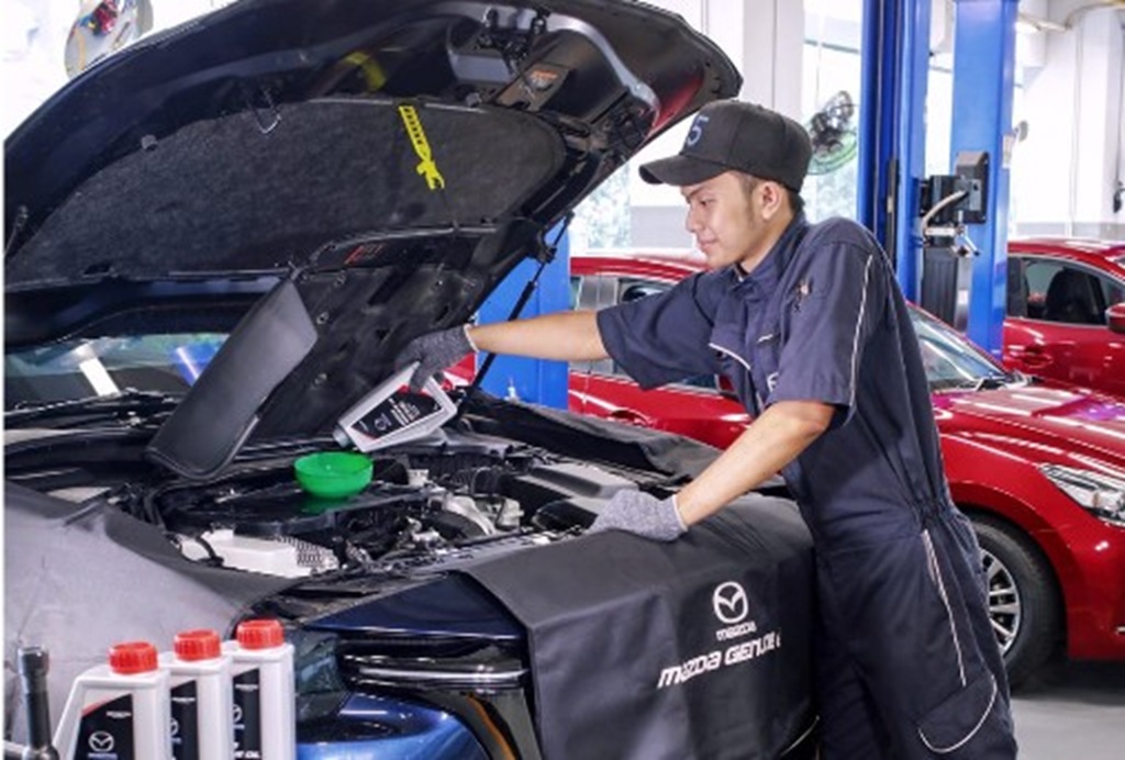 Seorang mekanik melakukan pengecekan pada salah satu unit Mazda di bengkel, beberapa waktu lalu.