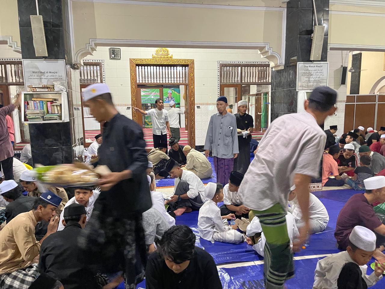 Ketua panitia Nuzulul Qur'an Habibi memantau pembagian gibungan pada jamaah yang hadir. 