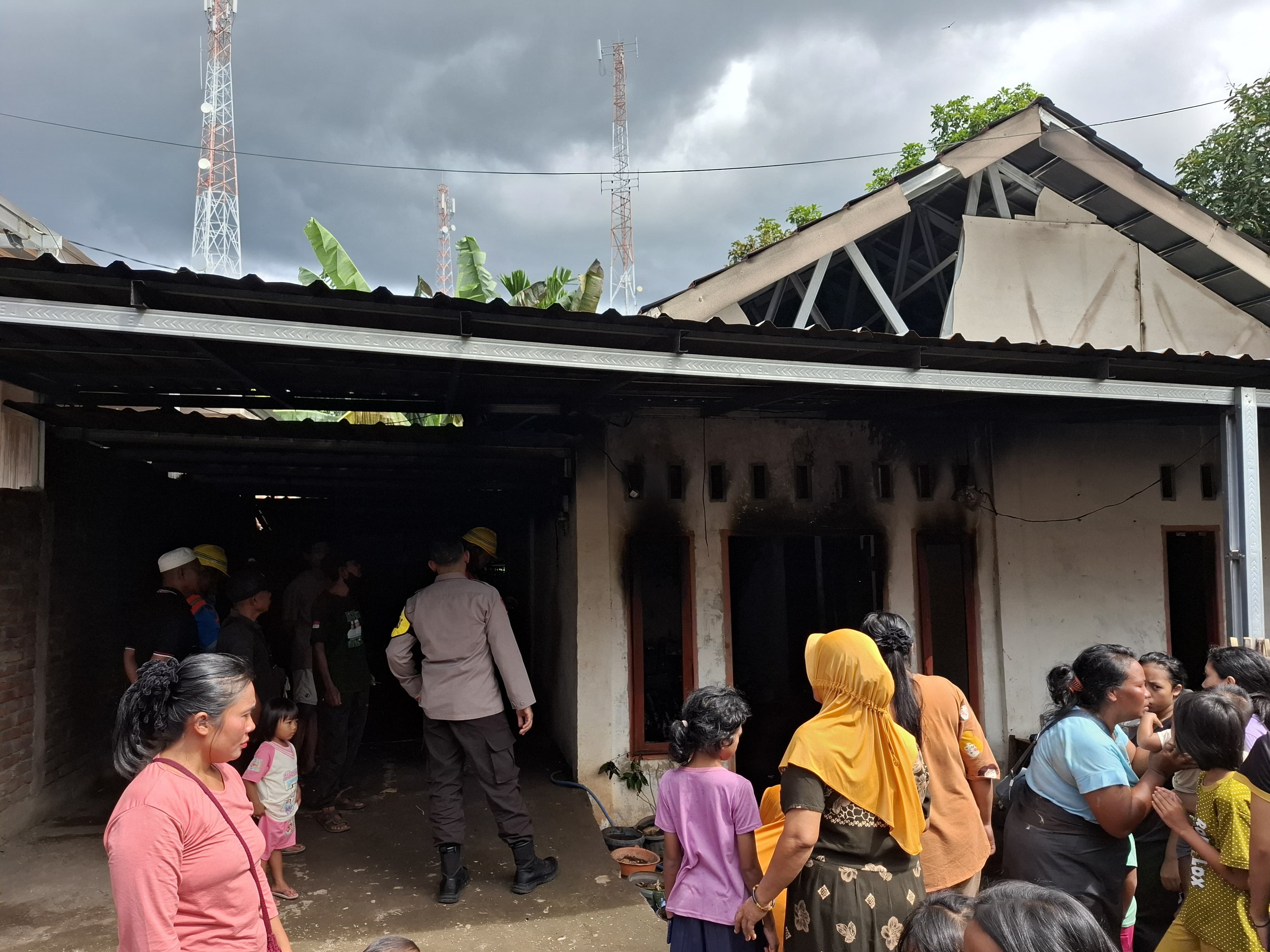Polisi bersama warga saat memadamkan api yang membakar satu unit rumah warga Sambelia, Lombok Timur. 