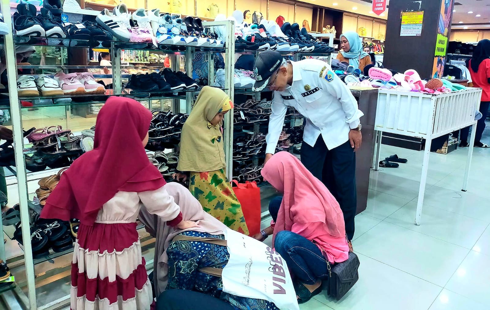 PEDULI: Kepala Desa Senggigi Mastur mendampingi puluhan anak yatim saat memilih pakaian lebaran di salah satu pusat perbelanjaan di Kota Mataram.