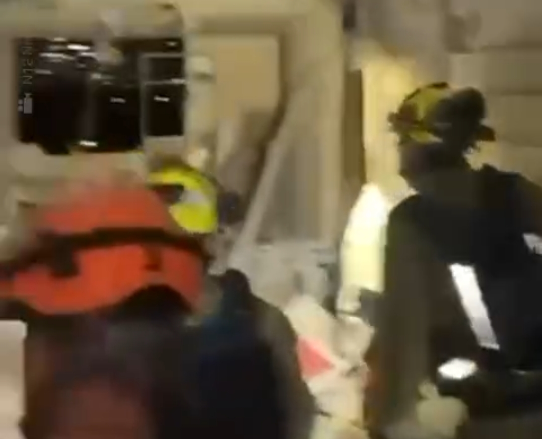 Aparat keamanan Israel saat menyusuri bangunan yang rusak akibat serangan rudal Iran di Tel Aviv. 