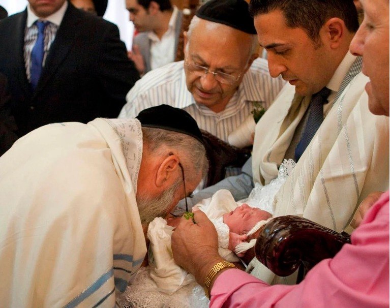 Bayi tengah menjalani ritual sunat tradisional yang melibatkan metode hisap oral oleh seorang Rabbi yaitu tokoh agama Yahudi. 