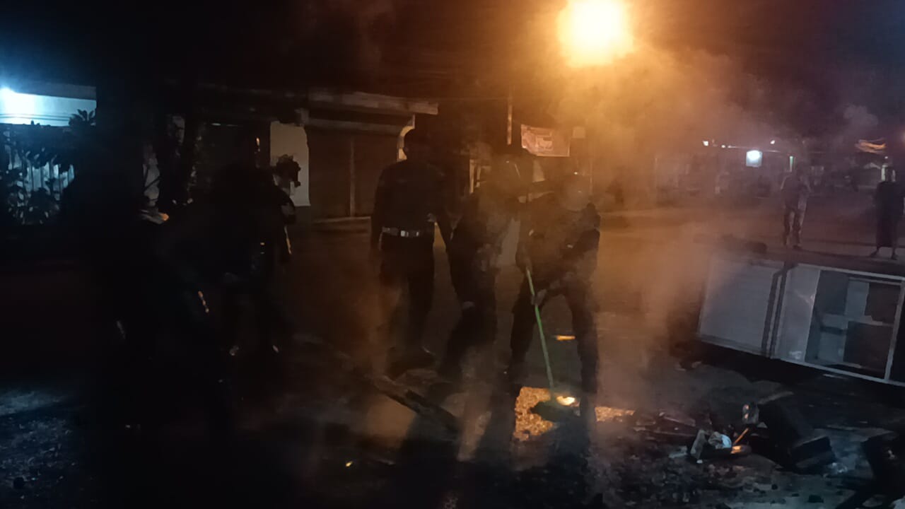 ANTISIPASI KONFLIK: Polisi membersihkan sejumlah puing bekas keributan antarwarga Petemon-Peresak, Minggu malam (22/2).