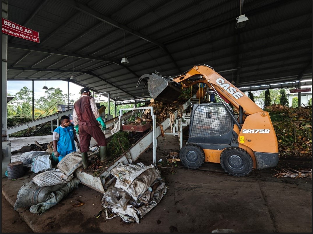 PROSES PENCACAHAN: Karyawan Pusat Pengolahan Organik Bakti Djarum Lingkungan Foundation memasukkan sampah organik ke mesin pencacah sebelum difermentasi menjadi kompos di Kudus.