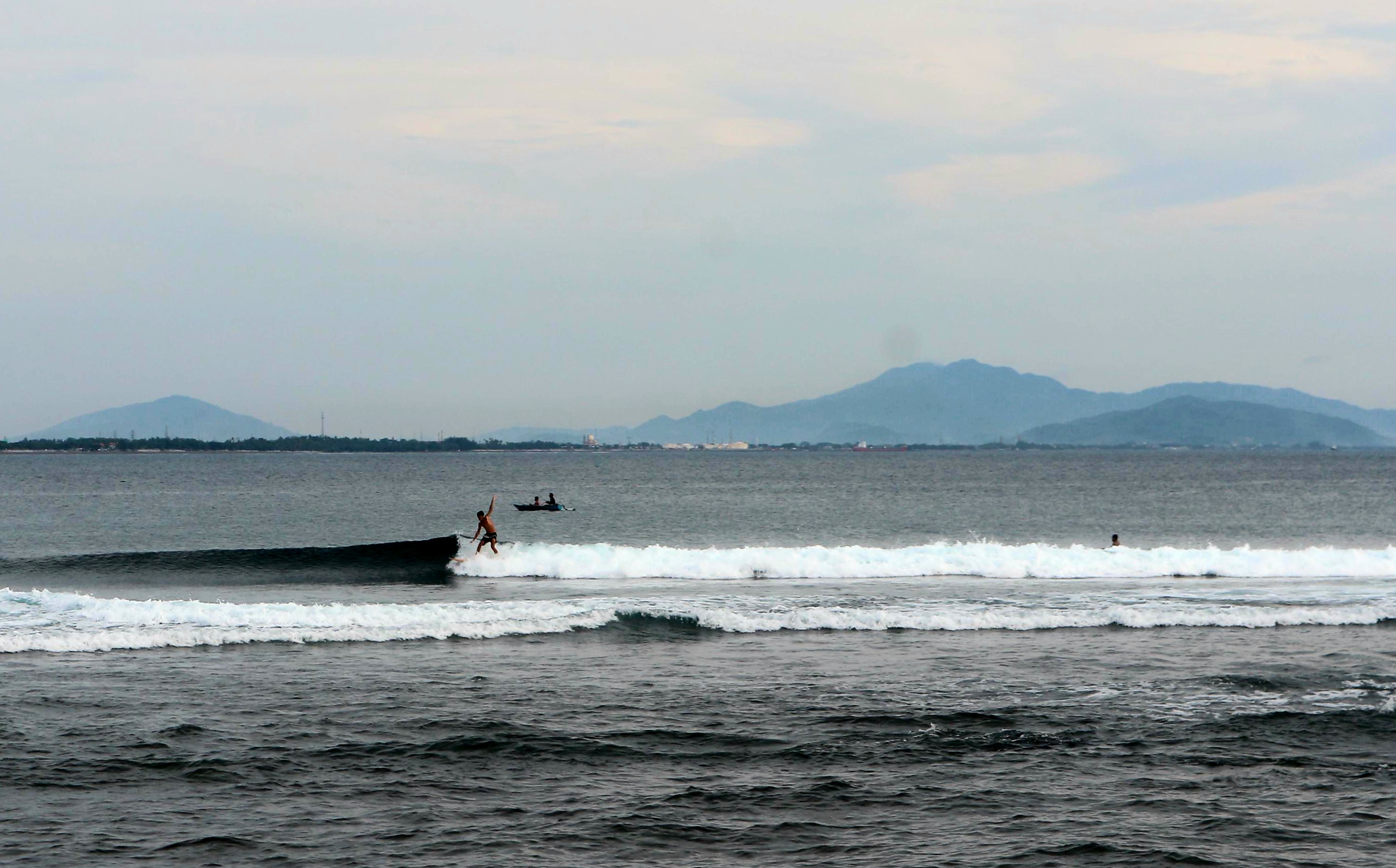 SURFING: Ombak di Pantai Senggigi menjadi salah satu sport surfing yang dicari wisatawan. 