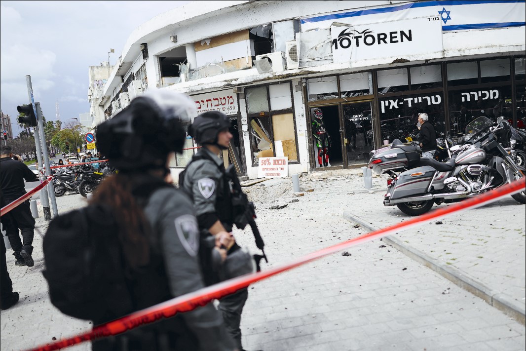 BERJAGA: Pasukan keamanan Israel mengepung sebuah tempat setelah serangan proyektil di selatan Tel Aviv pada Kamis (26/3). Konflik di Timur Tengah dipicu oleh serangan gabungan ASIsrael terhadap Iran.