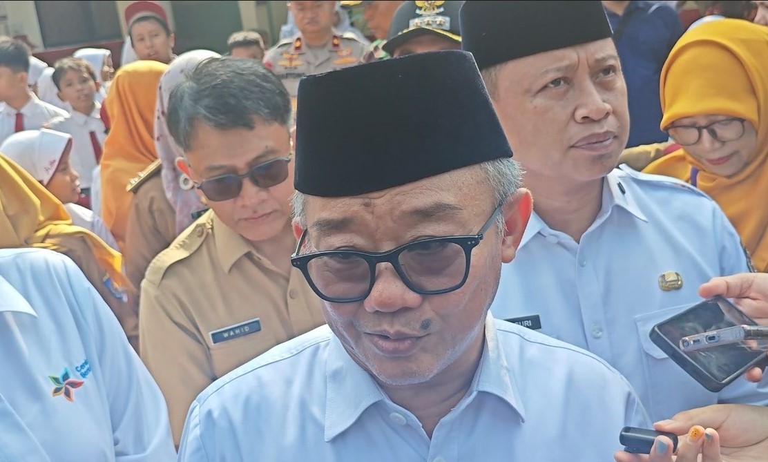 PENGATURAN PEMAKAIAN: Mendikdasmen Abdul Mu'ti saat menjadi pembina upacara di SMP Negeri 2 Depok Senin (30/3). (FEBRY FERDIAN/JAWA POS)