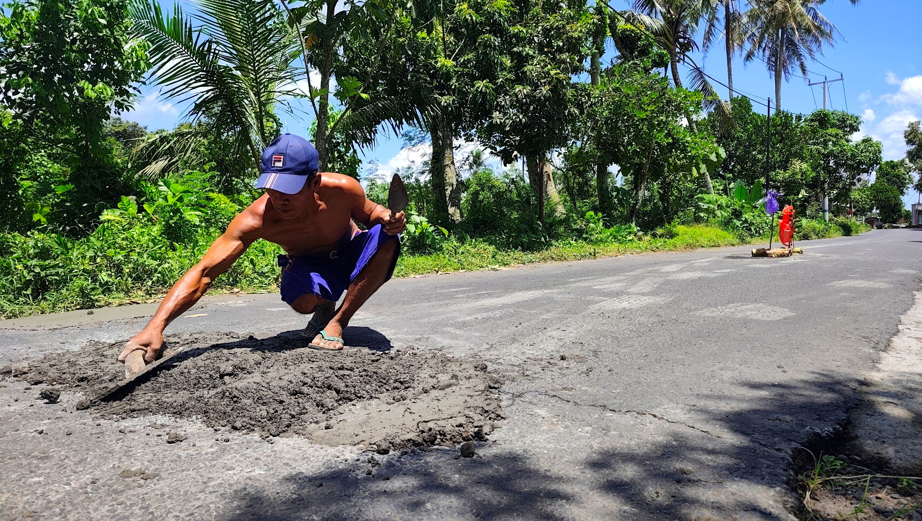 Sejumlah warga secara swadaya memperbaiki jalan berlubang pada ruas jalan di Desa Bonjeruk, Kecamatan Pringgarata, Senin (30/3).