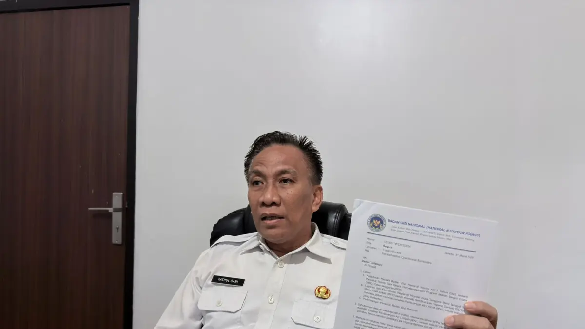 WAJIB BERBENAH: Ketua Satgas MBG NTB Fathul Gani menunjukkan surat pihak BGN yang memuat nama-nama SPPG yang dihentikan sementara operasionalnya, Rabu (1/4). (YUYUN/LOMBOK POST)