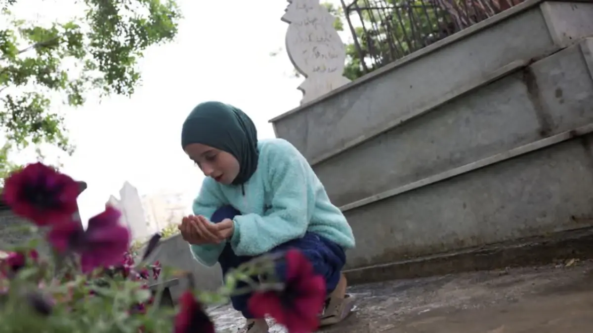 Seorang anak Lebanon tengah berdoa di makam keluarganya. 