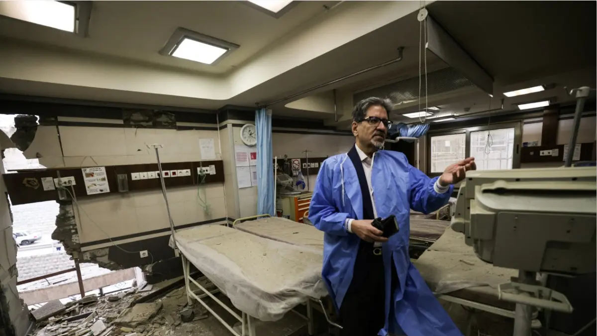 TETAP BERTAHAN: Seorang dokter berada di rumah sakit yang rusak karena serangan Amerika Serikat dan Israel. Dokter di Iran berusaha menghibur pasien anak di tengah perang. (ATTA KENARE/AFP)