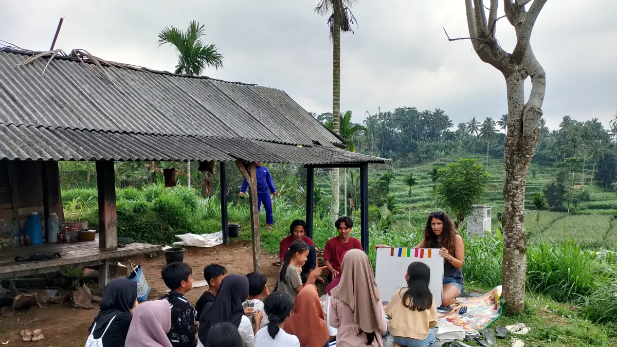 Anak-anak di Desa Jurit Baru sedang belajar bahasa inggris di gazebo tengah sawah, diajarkan salah seorang tamu mancanegara yang sedang liburan.