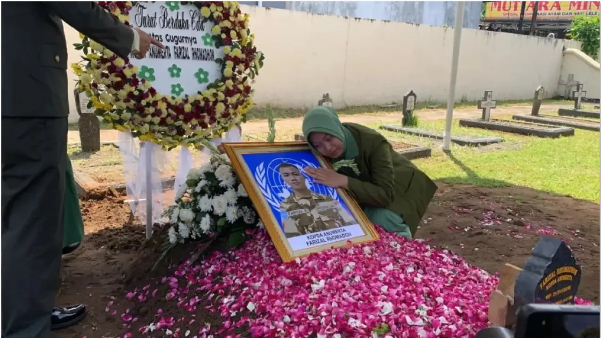 PAHLAWAN BANGSA: Fafa, istri Kopda Anm Farizal Romadhon di kuburan suaminya. (JAWA POS)
