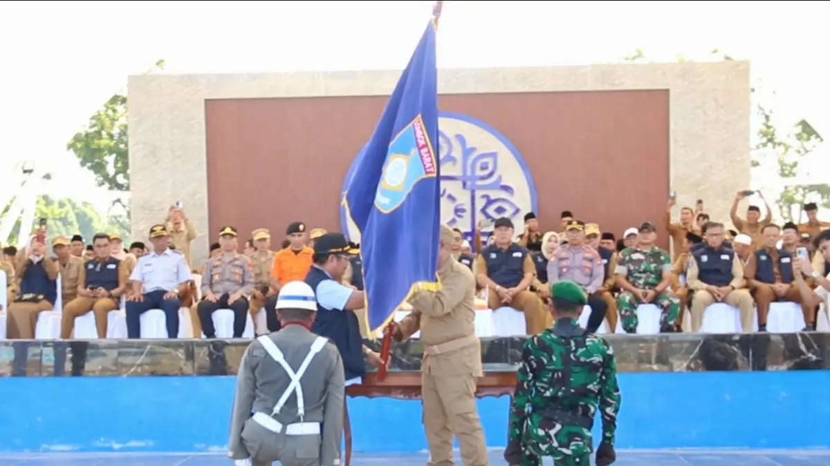 SEMARAK: Bupati Lobar Lalu Ahmad Zaini menyerahkan pataka kepada perwakilan kecamatan pada Kirab Pataka 2026 di Alun-Alun Giri Menang Park Gerung, Sabtu (4/4). (DOK PEMKAB LOBAR)