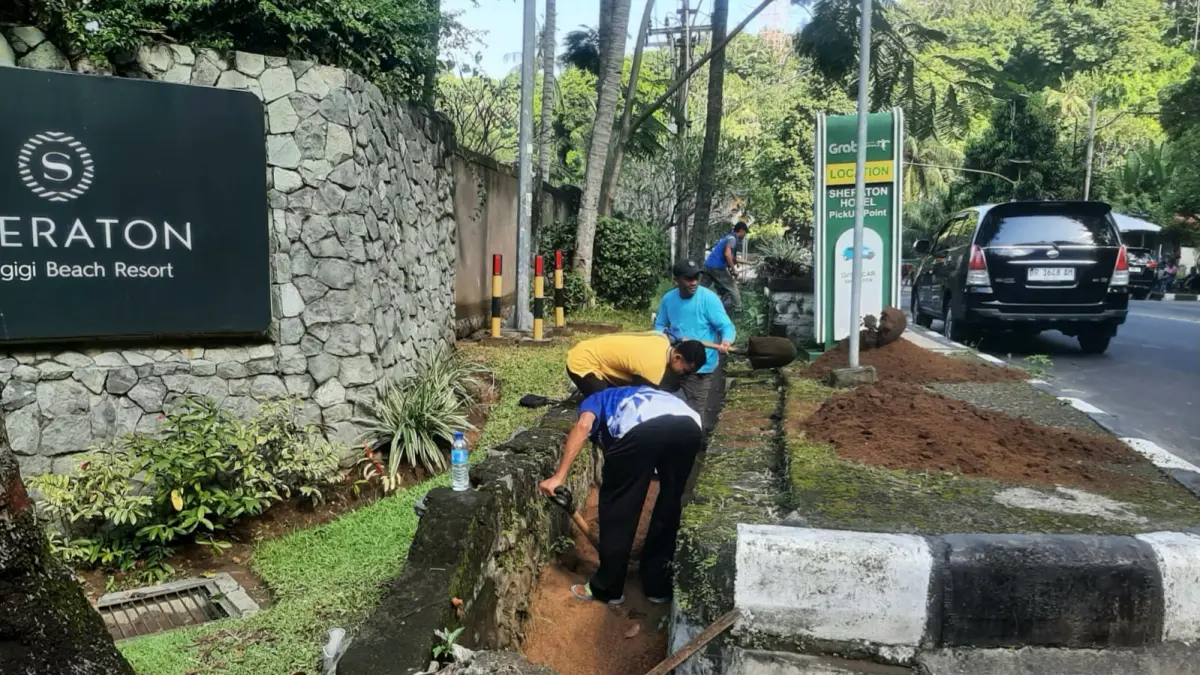 Petugas Dinas PUPRPKP Lobar melakukan pembersihan saluran drainase secara manual di kawasan Senggigi. (TONI/LOMBOK POST)