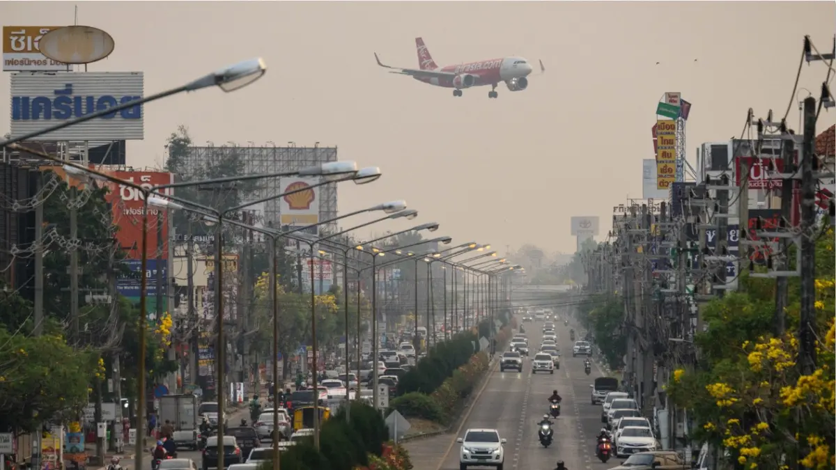 SIAP MENDARAT: Pesawat mengudara di atas jalan yang dipadati pengedara di Chiang Mai, Thailand, Selasa (7/4). (ANTHONY WALLACE/AFP)