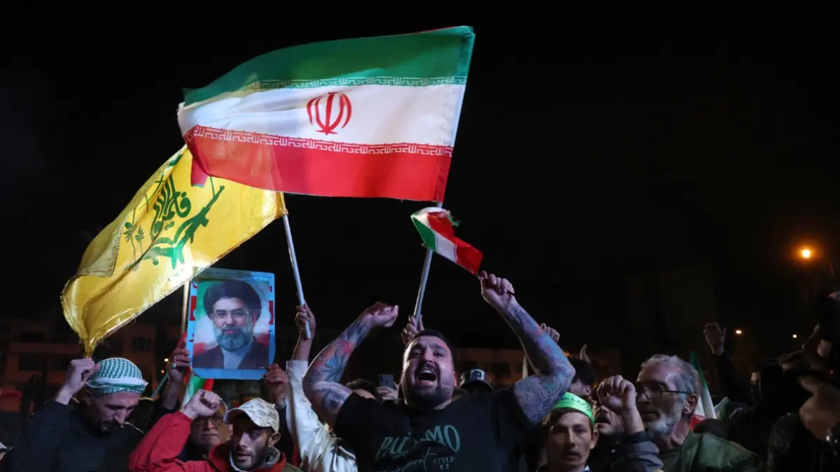 BERSORAK GEMBIRA: Warga Iran bergembira menyambut pengumuman gencatan senjata di Lapangan Enqelab, Teheran, Rabu (8/4). (ATTA KENARE / AFP)