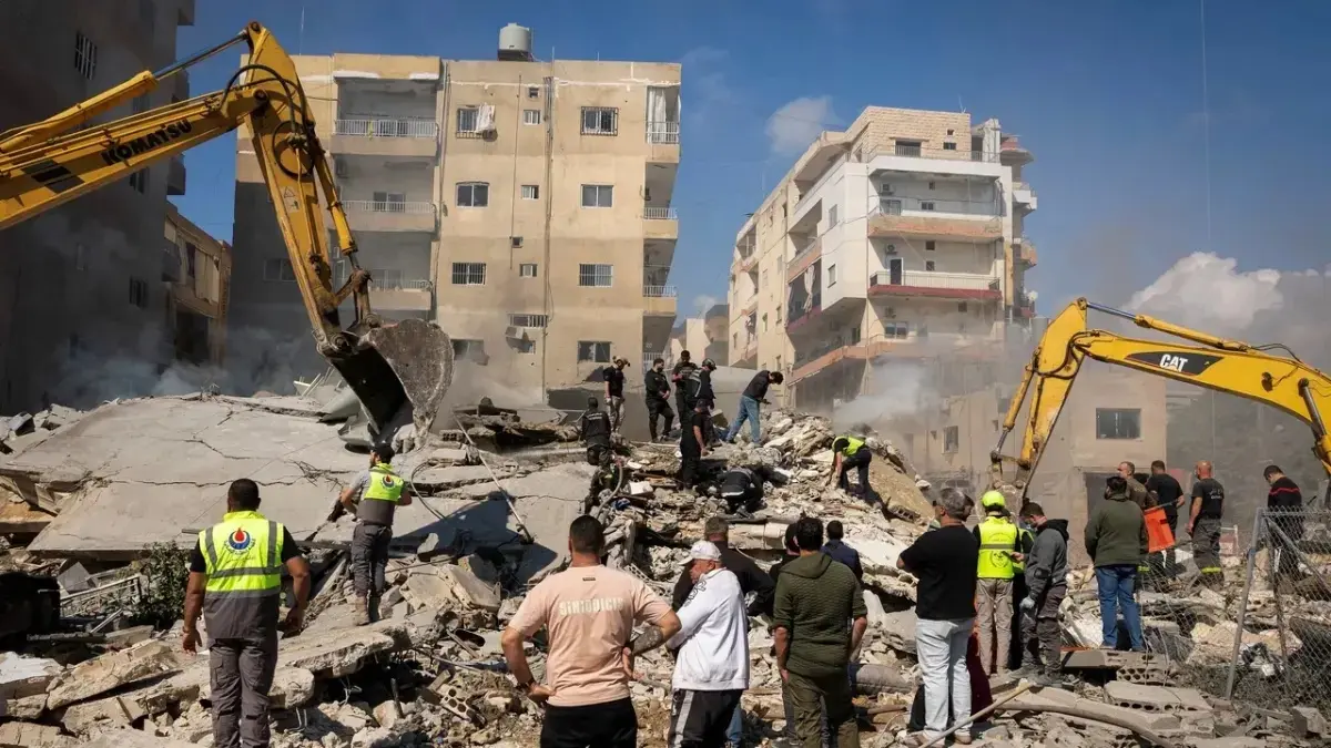 Petugas penyelamat berdiri di tengah puing-puing lokasi serangan Israel di Tyre, Lebanon. (TRT World)