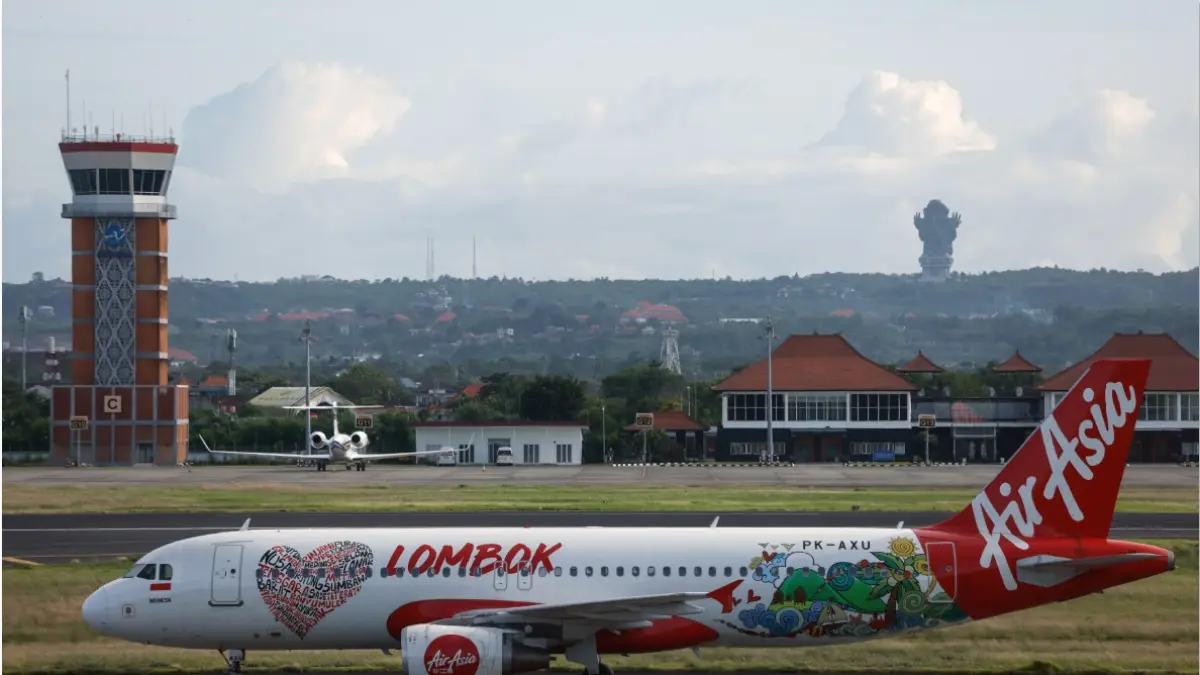 HARGA AVTUR NAIK: Sebuah pesawat penumpang Airbus A320 AirAsia melaju setelah mendarat di Bandara Internasional I Gusti Ngurah Rai di Bali, beberapa waktu lalu. Kenaikan harga avtur akibat perang di Timur Tengah menyebabkan biaya penerbangan haji naik. (DAVID GANNON/AFP)