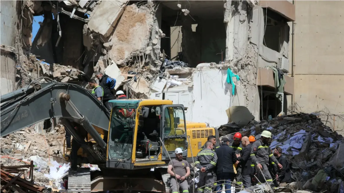 ANCAM GENCATAN SENJATA AS-IRAN: Tim penyelamat Lebanon menggunakan ekskavator untuk membersihkan puing-puing di lokasi serangan udara Israel yang menargetkan sebuah bangunan di lingkungan Tallet al-Khayyat, Beirut, Lebanon, Kamis (9/4). (IBRAHIM AMRO/AFP)