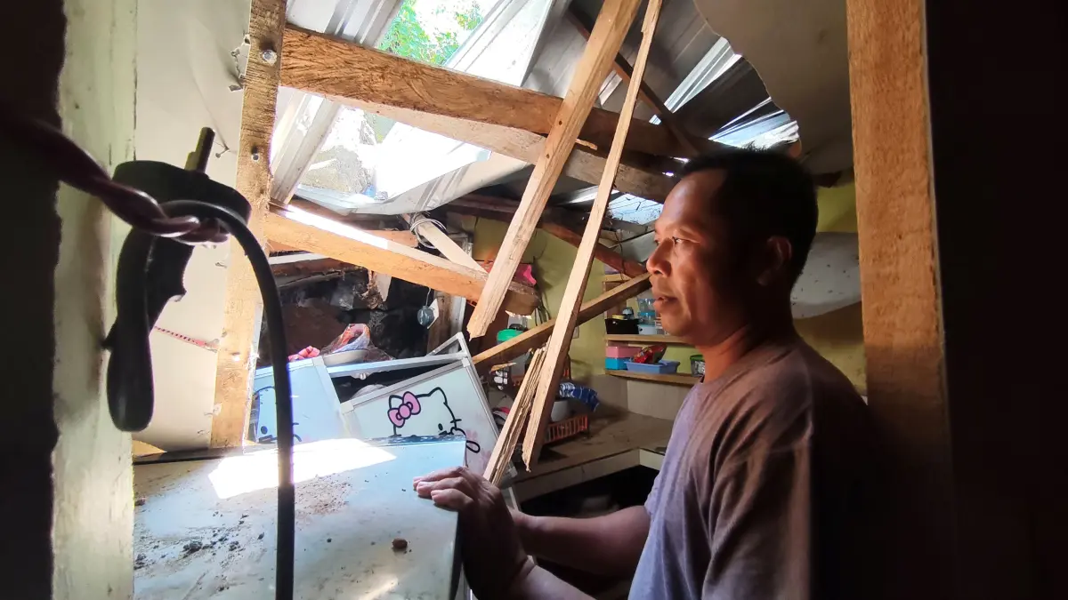 Pemilik rumah Misbah Rodhian menunjukkan kondisi dapur dan kamar mandi dikediamannya yang ambruk akibat tanah longsor di Dusun Mertak Waru, Desa Barabali, Batukliang, Lombok Tengah, Kamis (9/4). (Dewi/Lombok Post) 