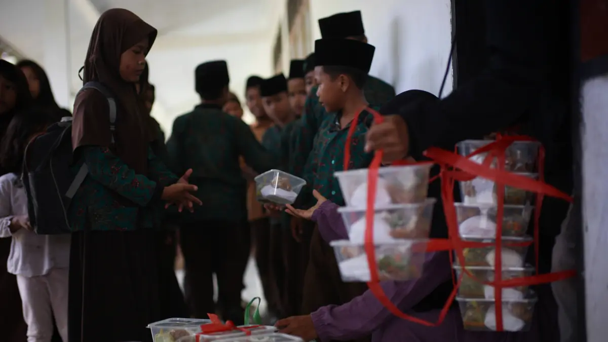 MENERIMA MANFAAT: Anak sekolah menerima kotak nasi berisi MBG, di salah satu sekolah di Dusun Aik Mual, Desa Mareje, Kecamatan Lembar, Lombok Barat, beberapa waktu lalu. (IVAN/LOMBOK POST)